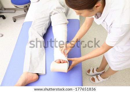 Nurses putting the bandage on the foot of the patient