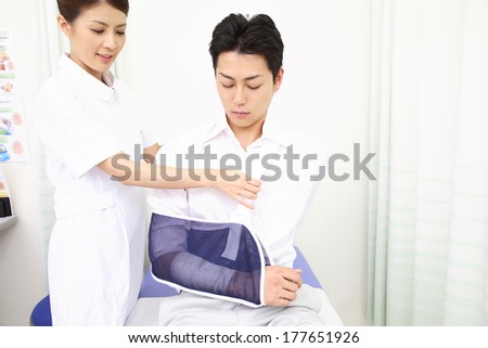 Japanese Nurse putting a patient\'s arm in a cast