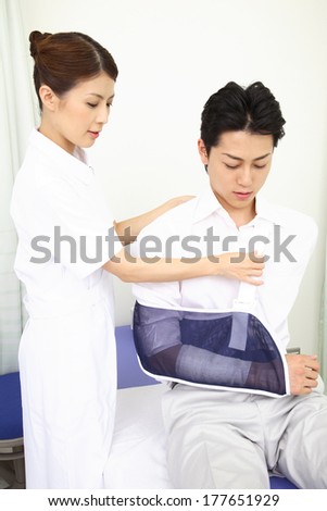 Japanese Nurse putting a patient\'s arm in cast