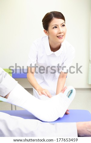 Japanese Nurse putting the bandage on the foot of the patient
