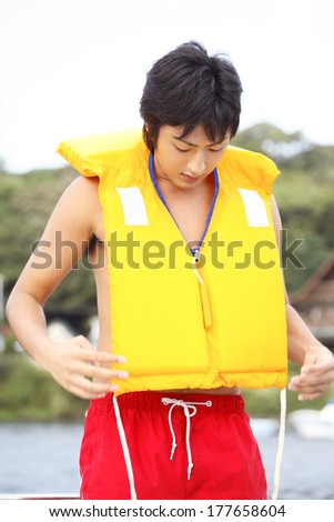 Japanese man putting on the life jacket