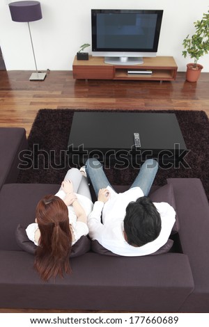 Rear View of Japanese couple watching TV in the living room