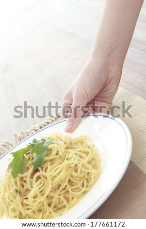 Hand of the Japanese woman putting the pasta on the table