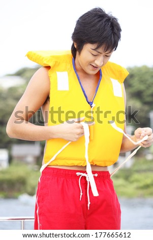 Japanese man putting on the life jacket