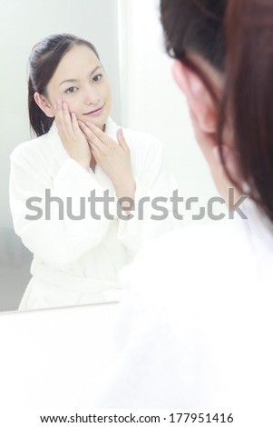 woman who look thoroughly at their skin in the wash basin