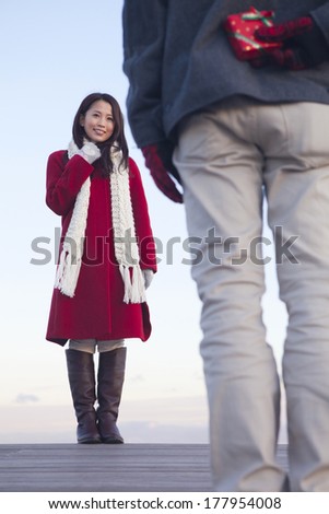 Back of Japanese men trying to pass a gift to woman