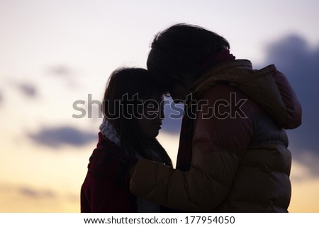 Silhouette of Japanese couple putting heads together
