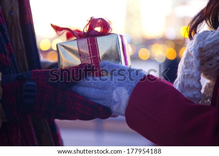 Hand of the Japanese woman passing a Christmas gift to men