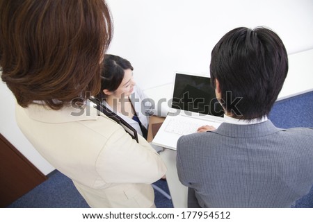 Back of Japanese office lady and businessman looking at laptop