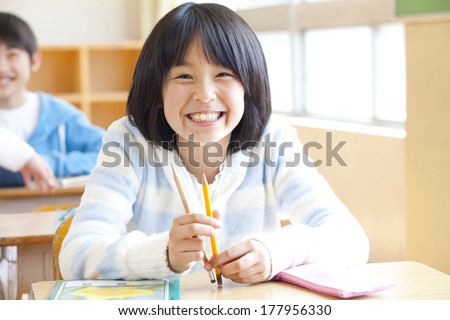 Japanese Primary school girl smiling and sitting on the seat