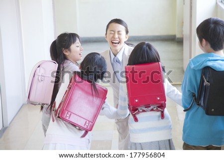 female Japanese teacher hugs students