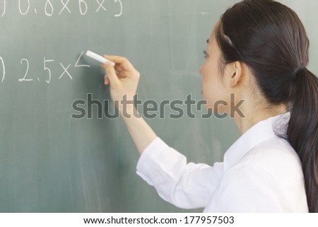 Female teachers to write a problem on the blackboard