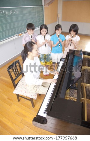 four Japanese students playing the recorder in the music room