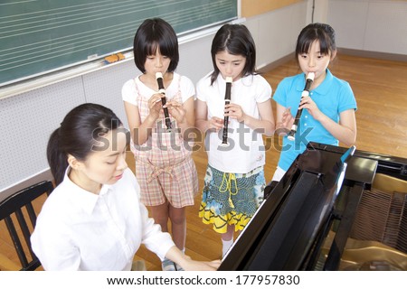 Primary student blow the recorder in the music room