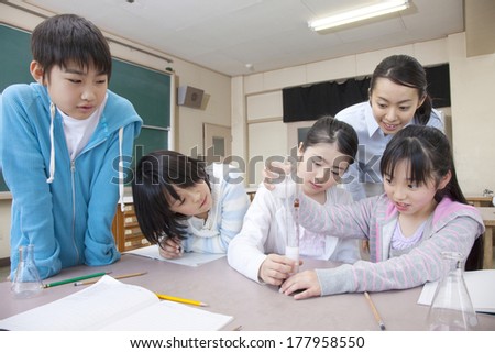 Primary boy, Japanese girl and the female teacher who experiment on the science