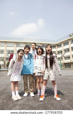 Female Japanese teachers and four elementary students smiling