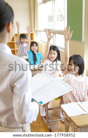 Four Primary Japanese students who raise their hands during class