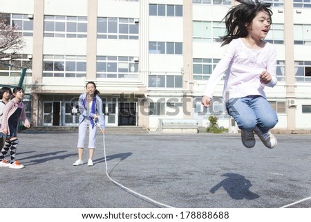 Japanese Primary student and teacher  jumping on a large rope
