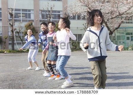 Teachers and four elementary children jumping rope