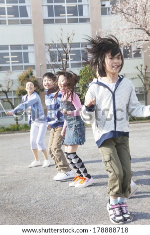 Teachers and four elementary children jumping rope