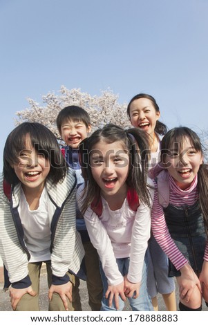 Japanese Female teacher and four elementary students smiling