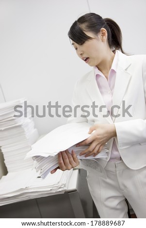 Japanese businesswoman organizing the large amount of paper