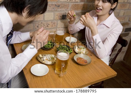 Japanese businesswoman and businessmen enjoying a meal in the pub
