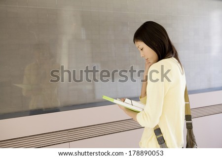 Japanese girl looking at a bulletin board