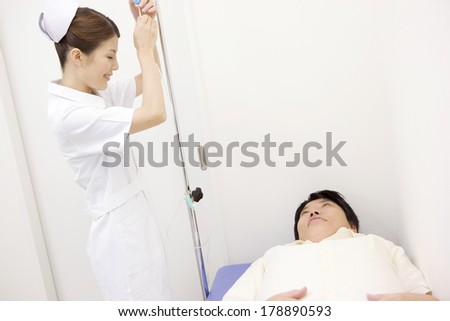 Japanese Nurse prepares an intravenous injection for patients lying in bed
