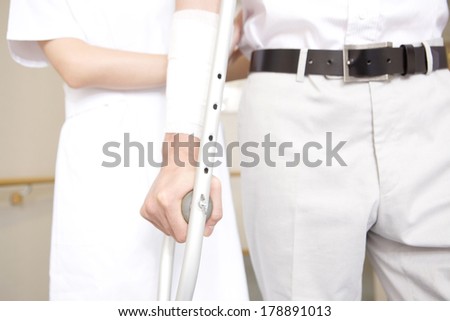 Nurse walking together with a patient with crutches
