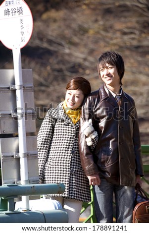 Japanese Couple standing at the bus stop