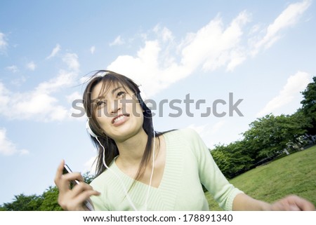 Japanese woman listening to music in the park
