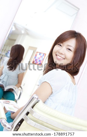 Japanese woman who turn around to sit in a chair in a hair salon