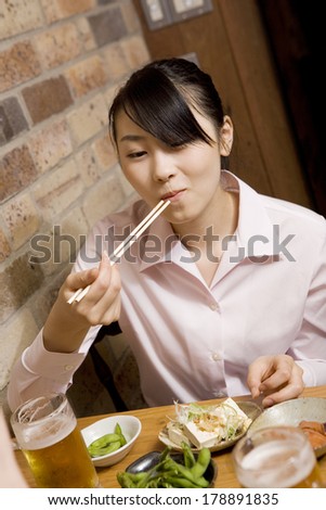 Japanese businesswoman enjoying a meal in the pub