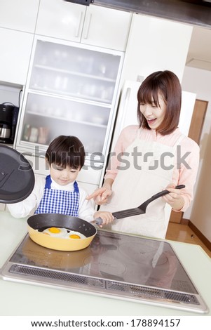 Japanese boy and Japanese woman cooking with eggs
