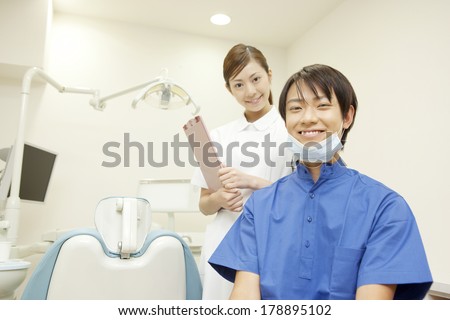 Dental hygienist and dentist with a smile in front of the treatment table