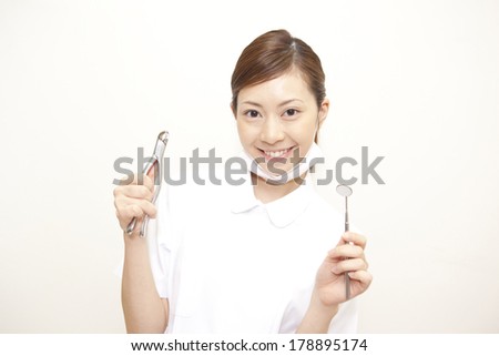 Japanese Dental hygienist smiling with a pliers and oral cavity mirror
