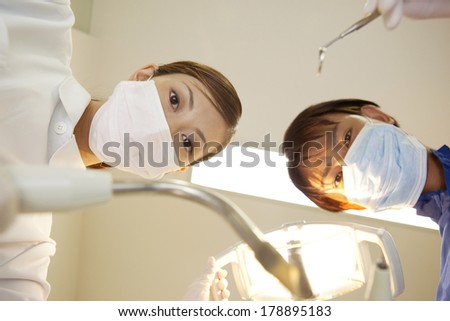 Japanese Dental hygienist and male dentist looking into the patient