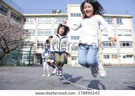 Primary Japanese student and teacher who jump a large rope