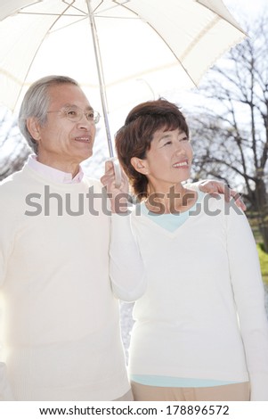 Senior Couples under a sun parasol