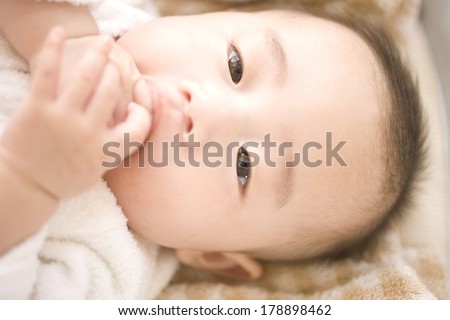 Baby biting finger in mouth