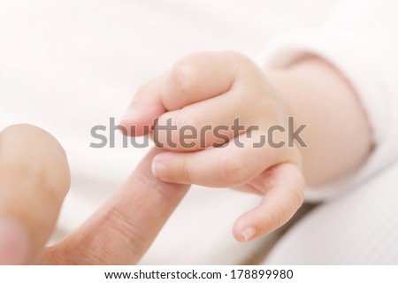 Hand the baby to grab the finger of father