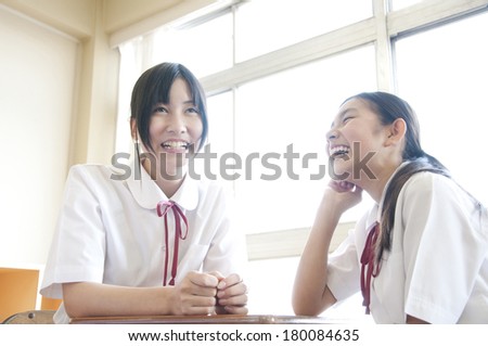Two Japanese middle school girls talking and laughing