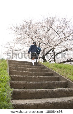 Uniformed Japanese schoolgirl going up stairs outside