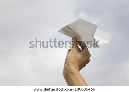 Hand holding a paper airplane