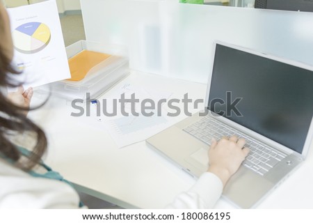 Japanese woman to operate the computer while watching the material