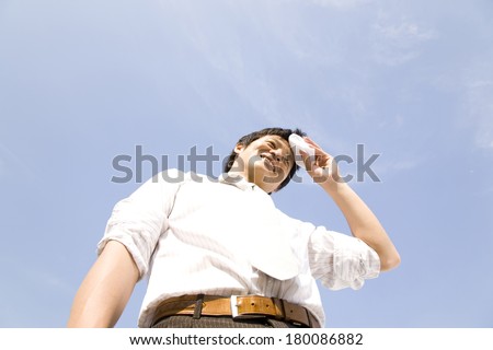 Japanese Businessman wiping off sweat from his forehead