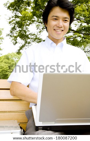 Businessman Using Laptop at a park bench
