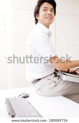 Businessman sitting on top of the desk
