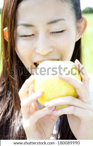 Japanese woman gnawing a green apple